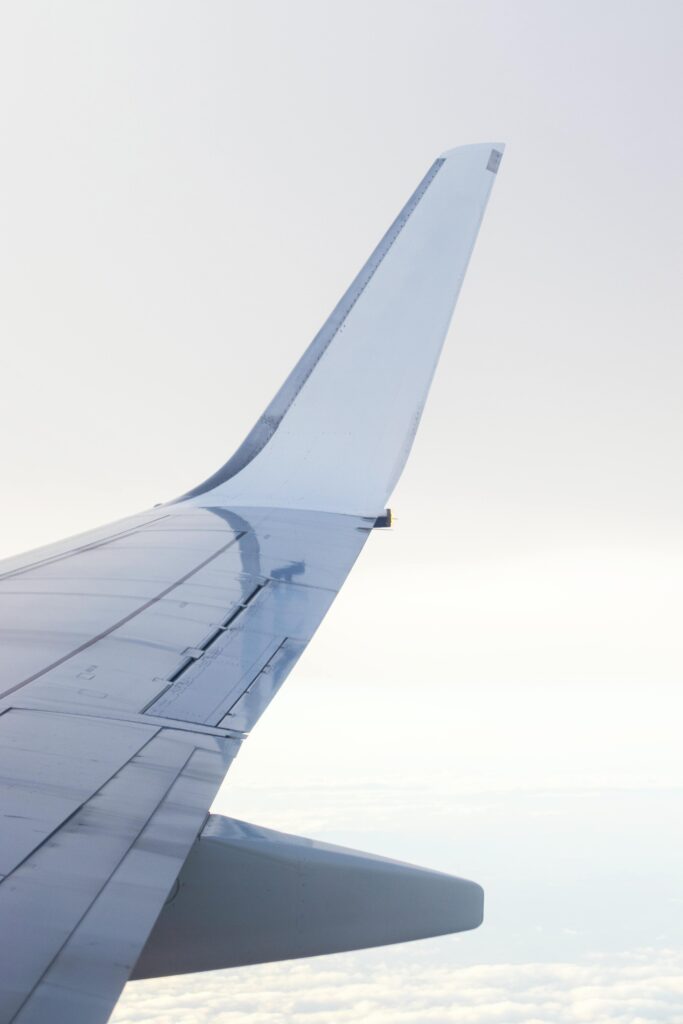 Aerial view from airplane wing over Warsaw, Poland, showing clear skies.